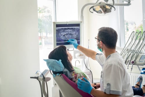 dentist explaining x-ray of teeth to patient