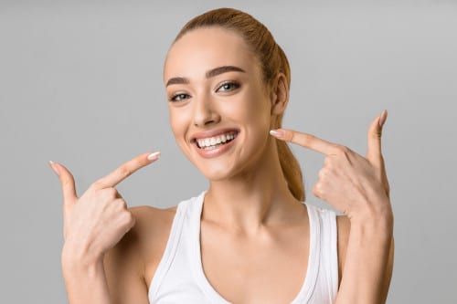 woman pointing at her smile